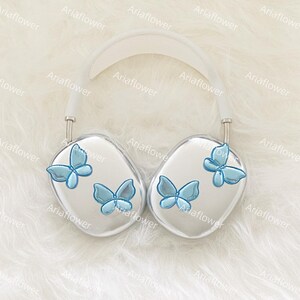 Peut inclure: Casque audio argent&eacute; orn&eacute; de papillons bleu clair. Le casque poss&egrave;de un arceau et des &eacute;couteurs blancs, chacun d&eacute;cor&eacute; de trois motifs de papillons bleus. Le design est &eacute;l&eacute;gant et moderne, avec une touche fantaisiste.