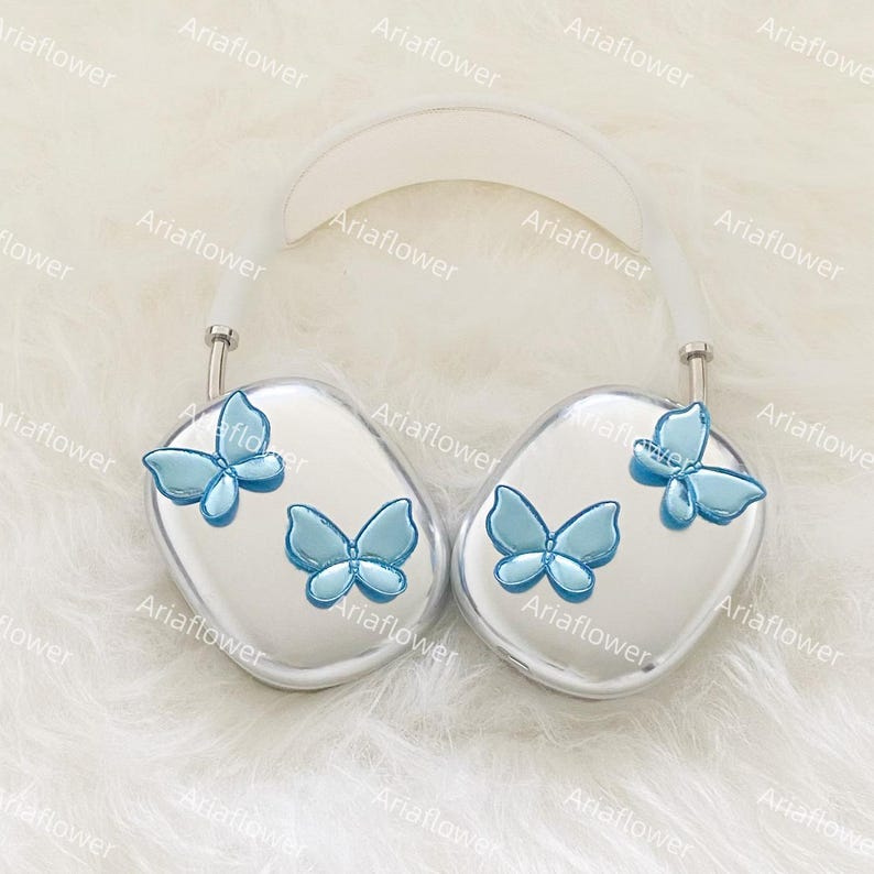 Peut inclure: Casque audio argent&eacute; orn&eacute; de papillons bleu clair. Les &eacute;couteurs pr&eacute;sentent des motifs de papillons en trois dimensions. L'arceau est blanc. Design moderne et &eacute;l&eacute;gant. Le texte "Ariaflower" est r&eacute;p&eacute;t&eacute; dans l'image.