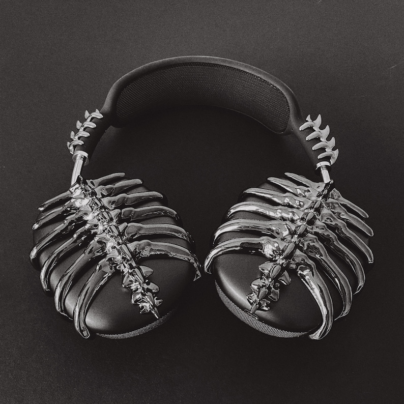 May include: Black headphones with a silver skeletal design. The headphones have a padded headband and earcups.