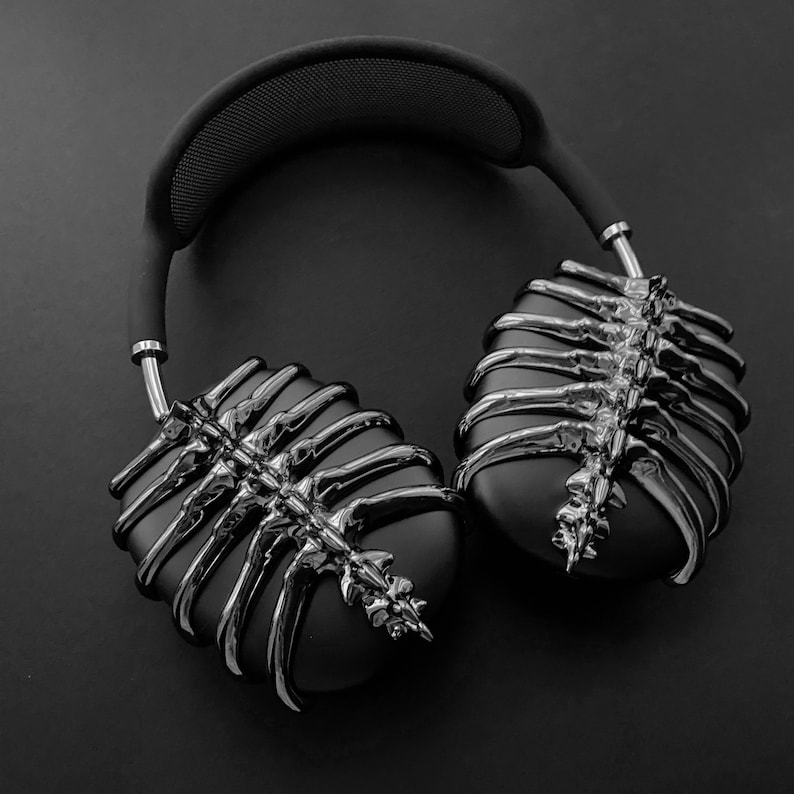 May include: Black headphones with a unique skeletal design on the earcups. The headphones are made of a smooth, glossy material.