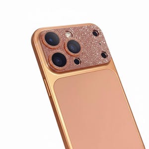 May include: Rose gold phone case with a glittery camera lens protector. The case has a smooth, matte finish on the back and a metallic frame. The camera lens protector has a sparkly, glittery finish.