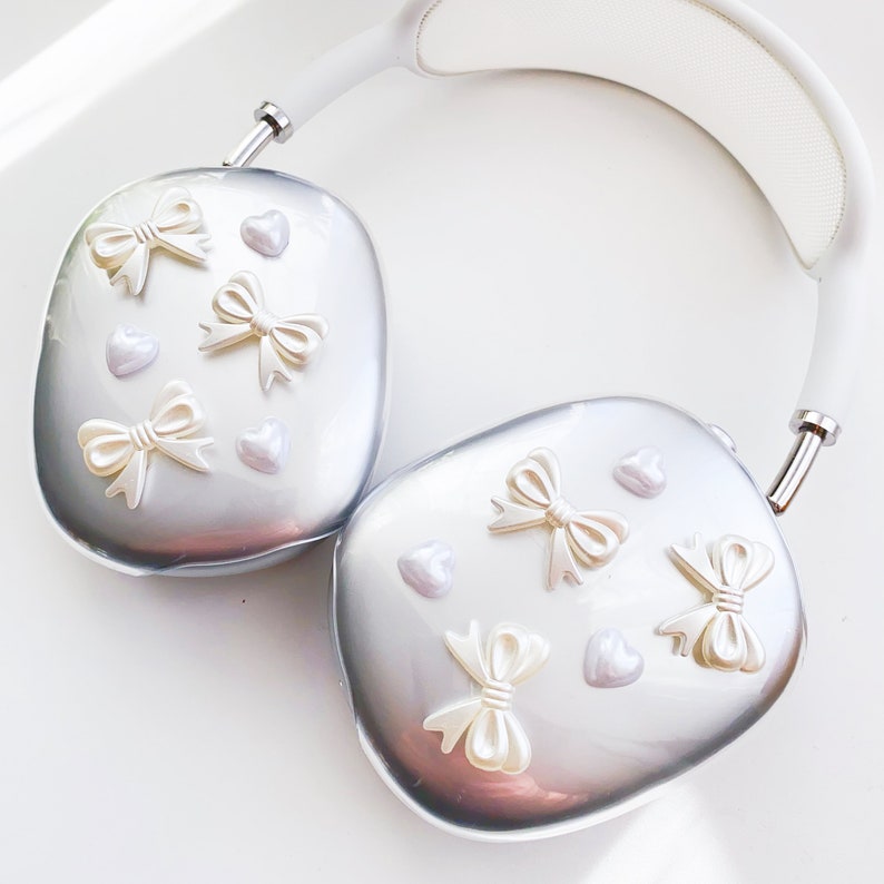 May include: White headphones with silver earcups decorated with white bows and hearts.