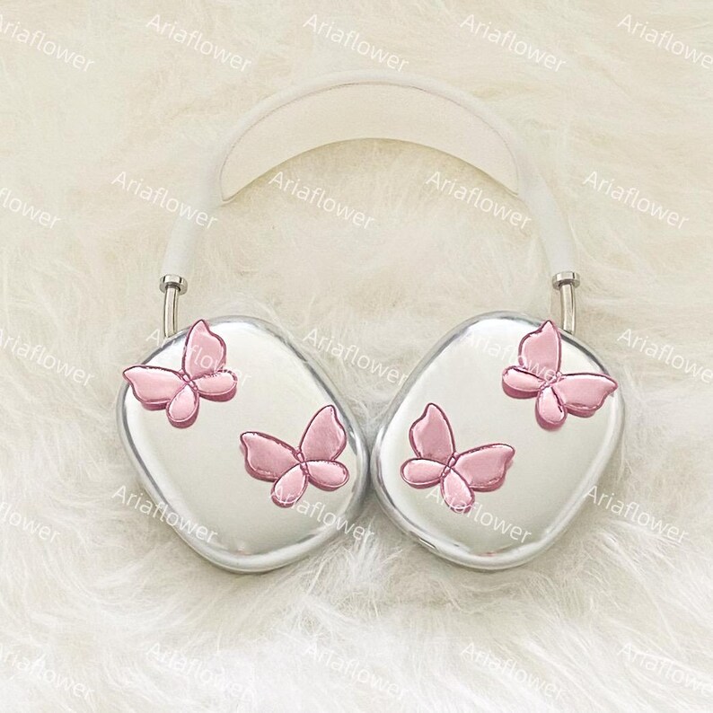 Peut inclure: Casque audio argent&eacute; avec un arceau blanc et des oreillettes orn&eacute;es de papillons roses. Ce casque, au design moderne, est probablement destin&eacute; &agrave; l'&eacute;coute de musique ou d'autres contenus audio.
