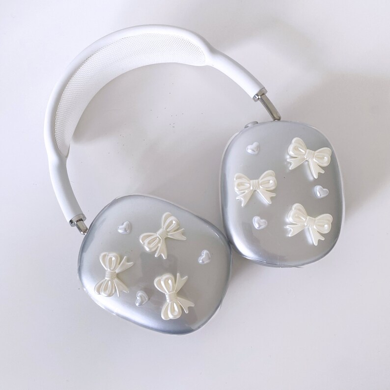 May include: White headphones with a silver earcup decorated with white bows and hearts.