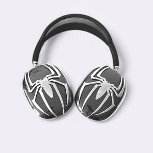 Pode incluir: Fones de ouvido pretos com um design de aranha prateada em cada fone de ouvido.