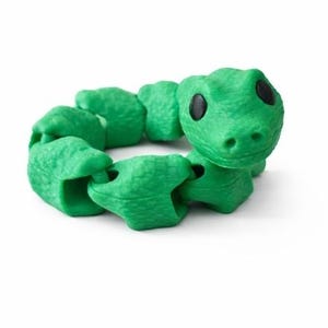 May include: A green, articulated snake toy with a textured surface and black eyes. The toy is coiled in a circle, with the head of the snake facing forward. The background is white.