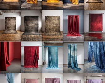 May include: A collection of studio backdrops in various colors and textures. The backdrops are draped over metal stands, showcasing a range of hues from warm yellows and oranges to deep reds, blues, and purples. The textures vary from smooth to mottled.