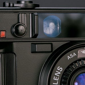 Close-up view of the Nikon L35AD (Pikaichi) film camera, showing the front viewfinder screen, lens and self timer control