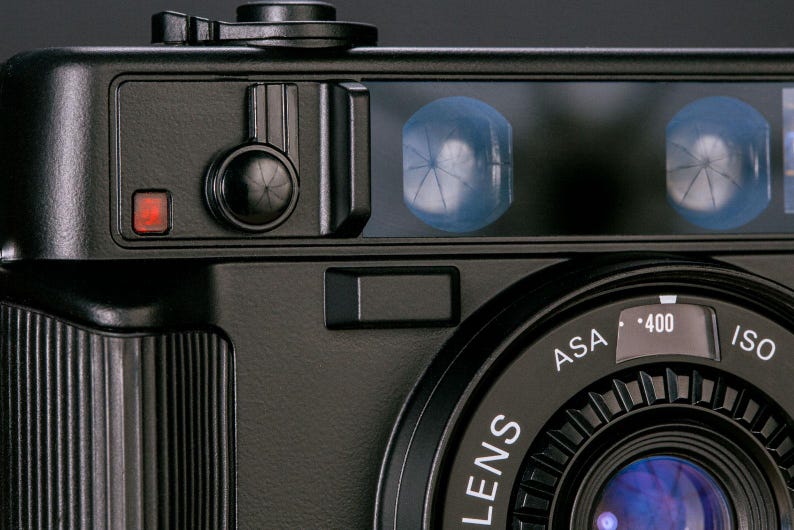 Close-up view of the Nikon L35AD (Pikaichi) film camera, showing the front viewfinder screen, lens and self timer control