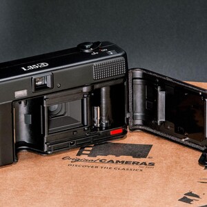 Back view of the Nikon L35AD (Pikaichi) film camera with the film door open, showing the interior film compartment.