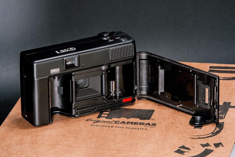 Back view of the Nikon L35AD (Pikaichi) film camera with the film door open, showing the interior film compartment.