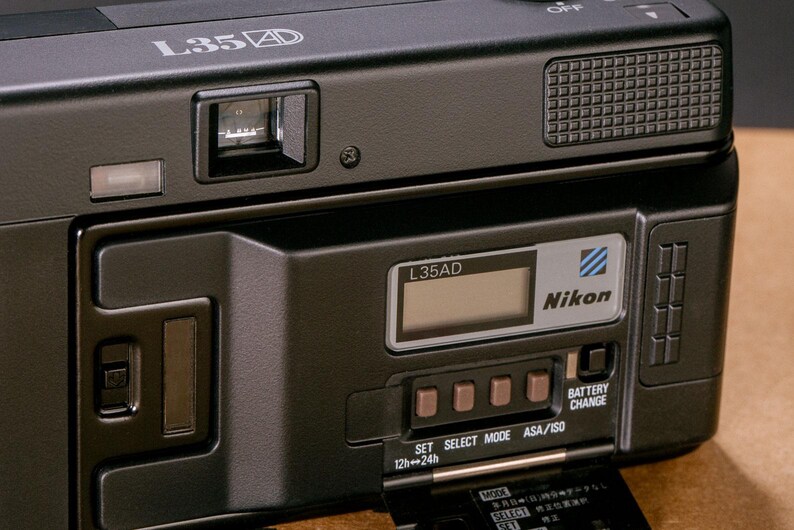 Back view of the Nikon L35AD (Pikaichi) film camera, showing the Quartz Date LCD screen and control buttons.