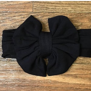 May include: A black fabric headband with a large, double-loop bow.