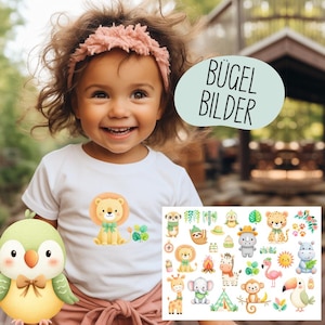 Könnte beinhalten: Ein Kind trägt ein weißes T-Shirt mit einem Löwen-Motiv. Das Bild enthält eine Sammlung farbenfroher Tierillustrationen und den Text "BÜGEL BILDER". Ein Plüschvogel befindet sich im Vordergrund.