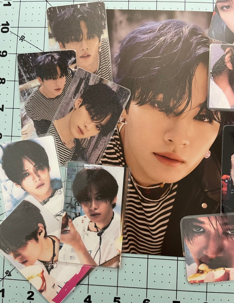 May include: A collection of photo cards featuring a young man with black hair. The cards are arranged in a grid pattern on a blue and white grid background. The cards show the man in different poses and outfits.