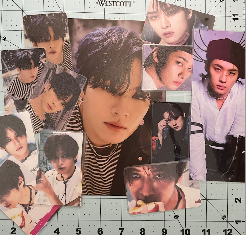 May include: A collection of photo cards featuring a young man with black hair. The cards are printed with different images of the man, including close-ups of his face, full-body shots, and shots of him wearing different outfits. The cards are all in a black and white color scheme.