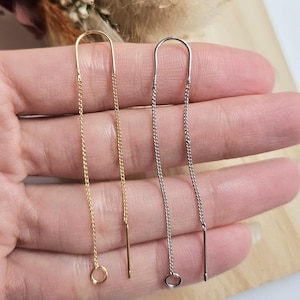 Peut inclure: Deux paires de boucles d'oreilles pendantes avec un design de chaîne. Une paire est dorée et l'autre est argentée.