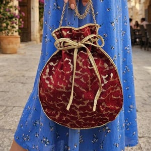 Sac bourse rouge et dorée pour femme invitée à une cérémonie