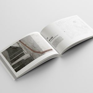 May include: An open book with a photo of a staircase with a wooden handrail on the left page and text on the right page that reads "01 AN ODE".