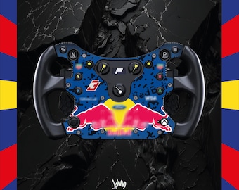 May include: A custom racing wheel with a blue and red design, featuring the Red Bull logo. The wheel has black handles and various buttons and controls. The background is a textured black surface, with a colorful border.