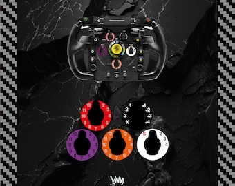 May include: A black Thrustmaster racing wheel controller featuring a central yellow button, multiple rotary dials, and toggle switches. Below the wheel are five circular adhesive decals in red, purple, orange, white, and black with various numbers.