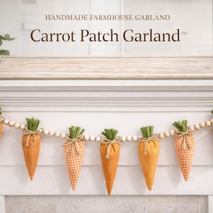 May include: A handmade farmhouse garland featuring orange carrot-shaped fabric decorations with green tops, strung on a natural twine with wooden beads. The garland is labeled "Carrot Patch Garland".