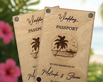 Könnte beinhalten: Zwei hölzerne Hochzeitspass-Einladungen mit dem Text "Wedding Passport" und einer gelaserten Palmen-Szene. Der Text "To the marriage of Melinda & Steven" ist ebenfalls zu sehen. Der Hintergrund zeigt tropisches Laub und das Meer.