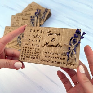 May include: Wooden save the date card with a calendar showing June 14, 2025, with a heart marking the date. The card also includes the text "Save the Date", "Gemma & Alexander", "Are getting married", "New Hampshire, NH", and "Formal invitation to follow".
