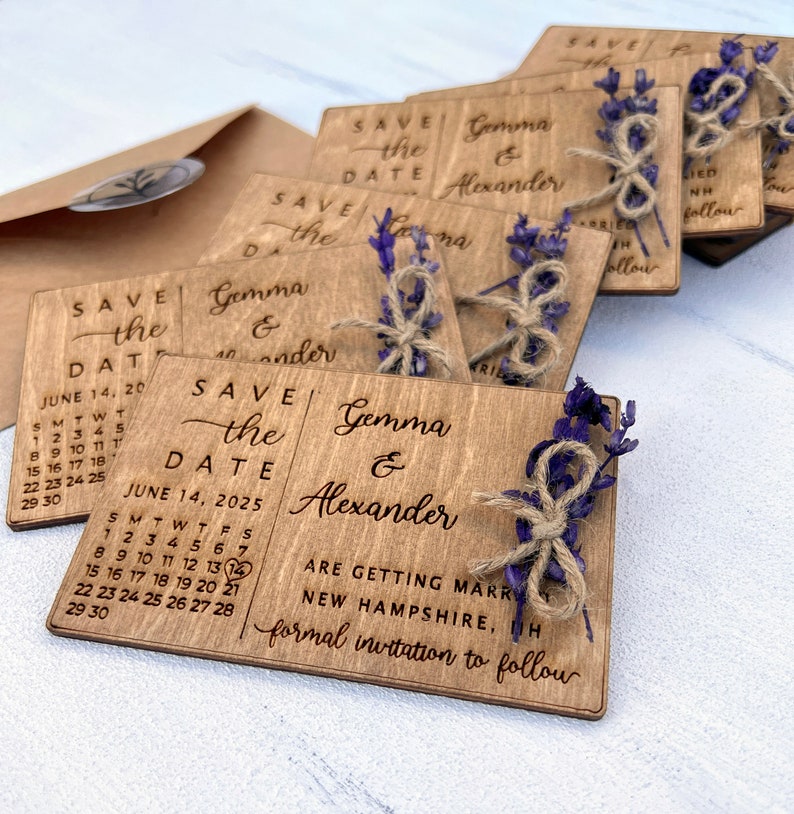 May include: Wooden save the date cards with a calendar design and the text "Save the Date" and "June 14, 2025". The cards also feature the names "Gemma & Alexander" and the text "Are getting married in New Hampshire, NH. Formal invitation to follow."