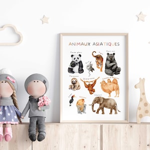 May include: A framed print titled "ANIMAUX ASIATIQUES" featuring watercolor illustrations of Asian animals, including a panda, tiger, and elephant. The print is displayed with two dolls and wooden decorations.