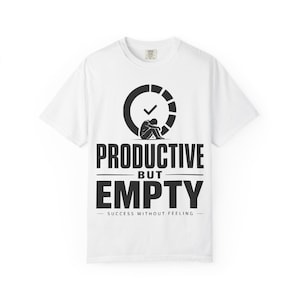 Pode incluir: Uma t-shirt branca de manga curta com um gráfico preto de uma pessoa sentada dentro de um ícone de relógio com um visto. O texto PRODUCTIVE BUT EMPTY e SUCCESS WITHOUT FEELING está escrito em letras pretas maiúsculas no peito.