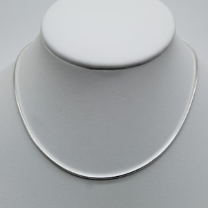 Op de afbeelding: Een delicate, zilverkleurige ketting gepresenteerd op een witte mannequin. De ketting heeft een dun slangkettingontwerp, waardoor een eenvoudige en elegante uitstraling ontstaat. De ketting is ongeveer 40 cm lang.
