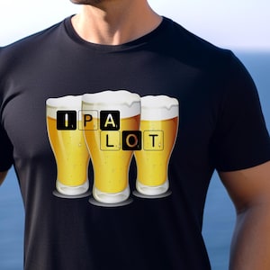Può includere: Una maglietta nera con una grafica di tre bicchieri di birra. I bicchieri sono pieni di un liquido giallo e hanno le lettere "IPA" e "LOT" su di essi.