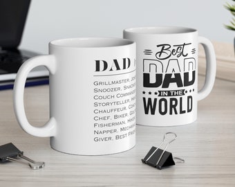 Op de afbeelding: Twee witte keramische mokken met zwarte tekst. De mok aan de linkerkant zegt "DAD" en somt een aantal rollen op, waaronder "Grillmaster, Snoozer, Snack Provider, Couch Commander, Storyteller,  H...
