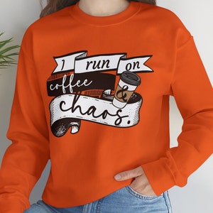 May include: Orange sweatshirt with a graphic design that says "I run on coffee & chaos".
