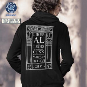 Puede incluir: Sudadera con capucha negra con un gr&aacute;fico blanco en la espalda. El gr&aacute;fico incluye el texto "LIBER AL" y otro texto en un dise&ntilde;o estilizado. La sudadera tiene una capucha con cord&oacute;n y un bolsillo de canguro. El logotipo de Blue Dog Shirts es visible.