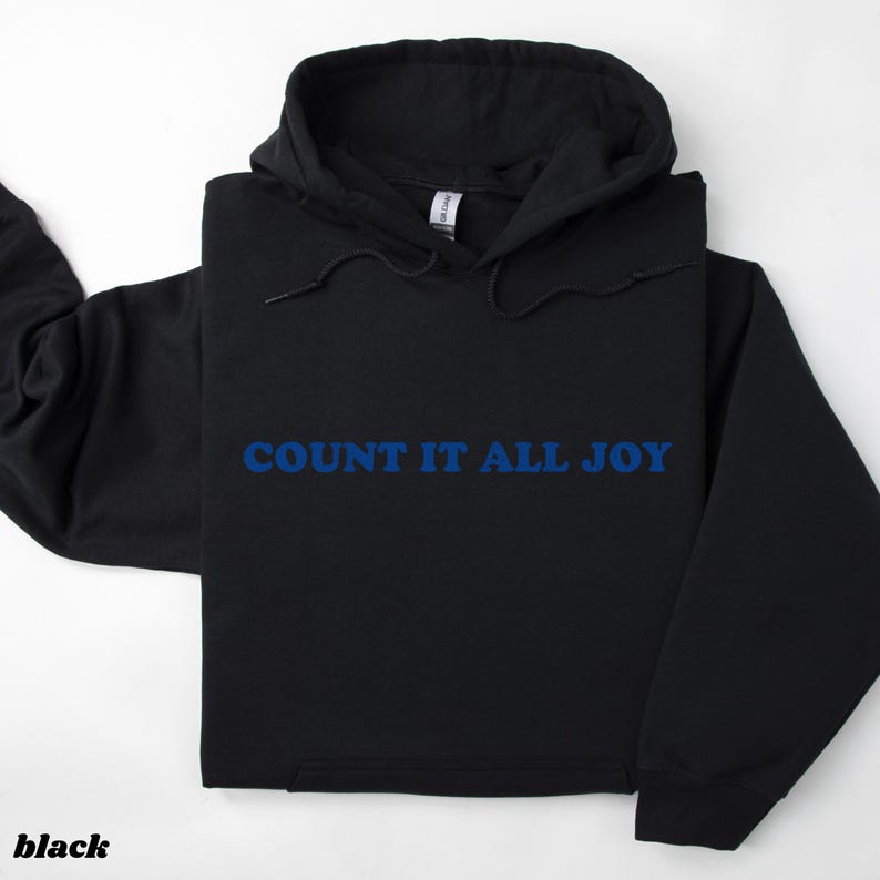May include: Black hoodie with the blue text "COUNT IT ALL JOY". The hoodie has a drawstring hood and a front pocket. The word "black" is printed at the bottom left corner of the image.
