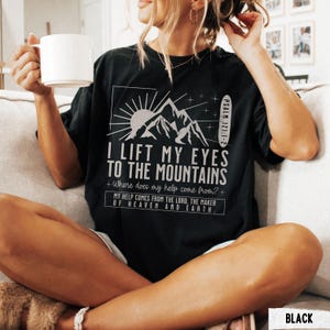 May include: Black t-shirt with the text "I Lift My Eyes to the Mountains" and a mountain graphic. The shirt also includes the text "Where does my help come from?" and "My help comes from the Lord, the maker of heaven and earth."