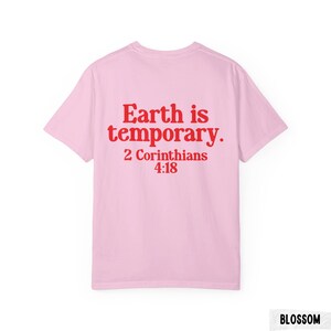 Pode incluir: T-shirt rosa claro com a frase vermelha "Earth is temporary. 2 Cor&iacute;ntios 4:18" nas costas. A t-shirt tem um estilo de gola redonda.