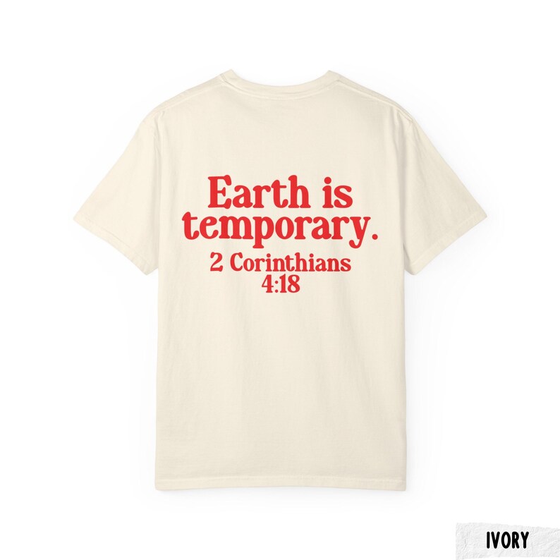 Pode incluir: Camiseta de cor marfim com o texto vermelho "Earth is temporary. 2 Corinthians 4:18" impresso nas costas. A camiseta &eacute; de estilo gola redonda e &eacute; feita de um tecido macio. Uma pe&ccedil;a de roupa casual.