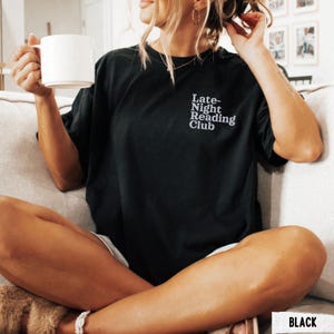 Puede incluir: Una camiseta negra con el texto "Late-Night Reading Club" en letras blancas.
