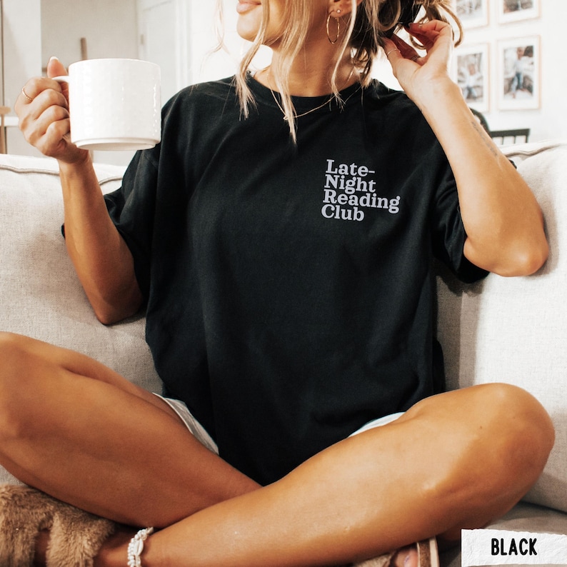 Puede incluir: Una camiseta negra con el texto "Late-Night Reading Club" en letras blancas.