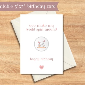 May include: A printable 5"x7" birthday card with a pink and white color scheme. The card features a line drawing of a stationary exercise bike with the text "you make my world spin around" and "happy birthday".