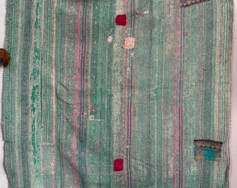 May include: A handmade, vertically striped quilt in shades of green, pink, and purple. The quilt features patches of turquoise fabric with ornate designs and small, square, red patches. The quilt is a unique, handcrafted textile.