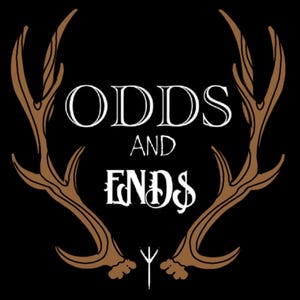 May include: A black and white graphic design with the text "ODDS AND ENDS" in a stylized font. The text is framed by two brown antlers.