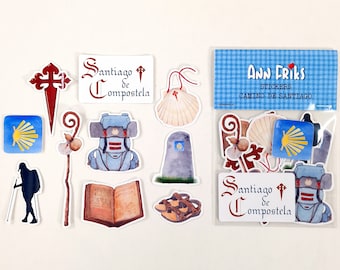 Può includere: Un set di adesivi con illustrazioni di simboli e oggetti legati al pellegrinaggio del Cammino di Santiago. Gli adesivi sono in un sacchetto di plastica trasparente con un'etichetta blu e bianca che recita "Ann Friks Stickers Camino de Santiago". Gli adesivi includono una conchiglia di capesante, un bastone da pellegrino, uno zaino, un libro, una croce e un pellegrino.