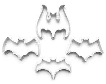 Könnte beinhalten: Vier weiße, plastikförmige Fledermaus-Ausstecher. Die Ausstecher sind in einem Kreis auf weißem Hintergrund angeordnet.