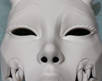 May include: White ceramic mask with horns, detailed eyes, and a fanged mouth. The mask is in a traditional Japanese style.