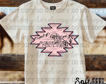 Może przedstawiać: Biały T-shirt z różowo-niebieskim wzorem w stylu południowo-zachodnim, przedstawiającym czarną sylwetkę kowboja na koniu z bydłem w tle. Wzór zawiera góry i kaktusa. Tekst "Soft FEEL DTF Transfers & Tees" znajduje się w prawym dolnym rogu.