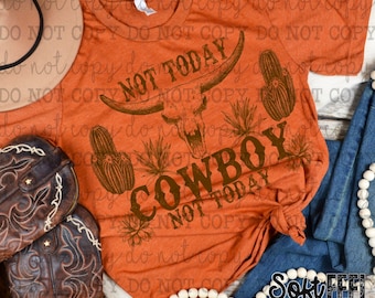 Op de afbeelding: Een roestkleurig T-shirt met een grafisch ontwerp van een koeien schedel met hoorns, cactussen en de tekst "Not Today Cowboy Not Today".